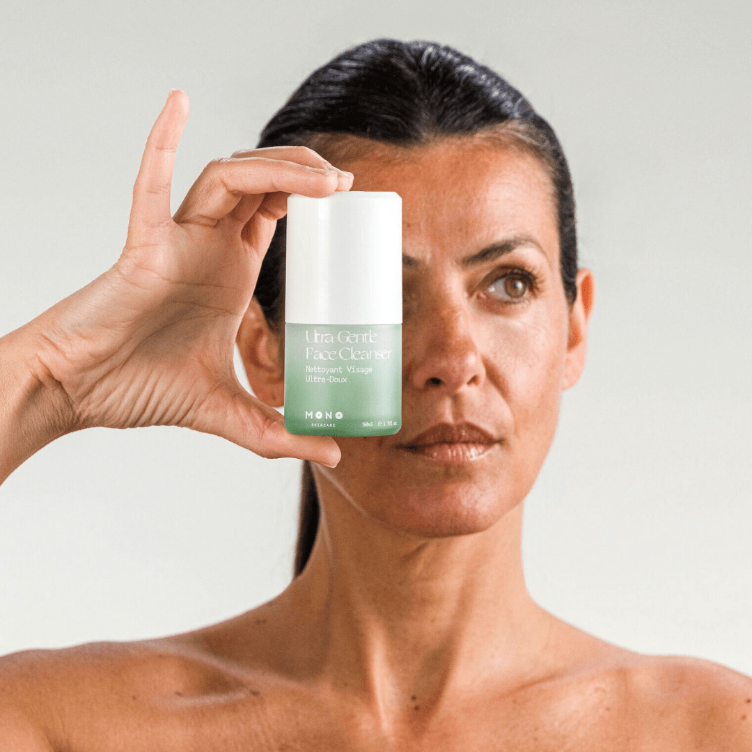 Femme tenant le nettoyant visage ultra-doux MONO – soin naturel pour nettoyer sans agresser la peau