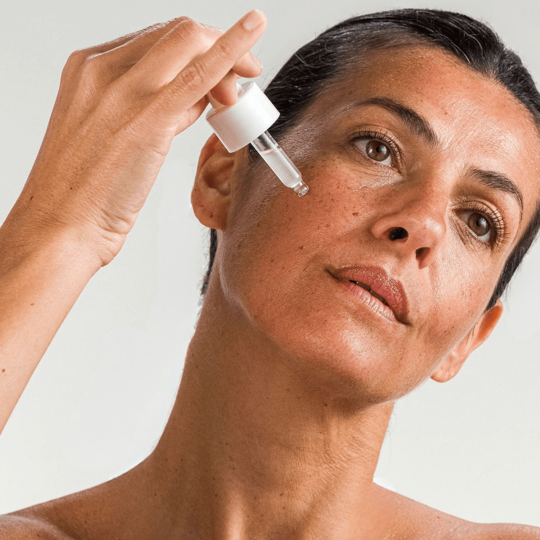 Femme tenant le sérum de nuit hydratation intense MONO – soin réparateur et nourrissant pour la peau